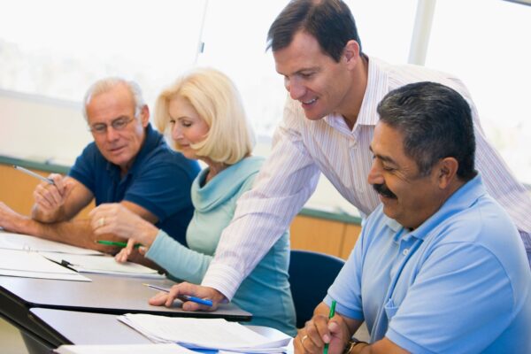 A group of people sitting at a table with papers.